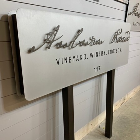 Layered powder-coated aluminum post-mounted sign for Auburn Road Vineyards in matte silver and black posts.