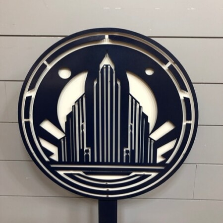 Techno Deco Records round sign with an art-deco skyline cut through a navy disc, on a post.