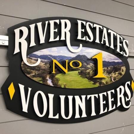River Estates No 1 Volunteers sign in black and white, a river valley scene printed at its center.