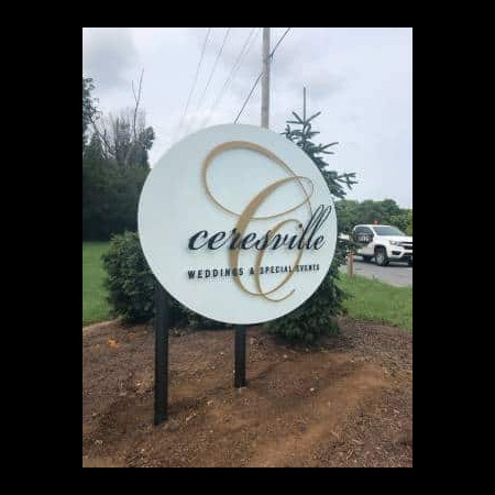 Ceresville Mansion post-mounted round sign in white with a gold C monogram, reading Weddings & Special Events.