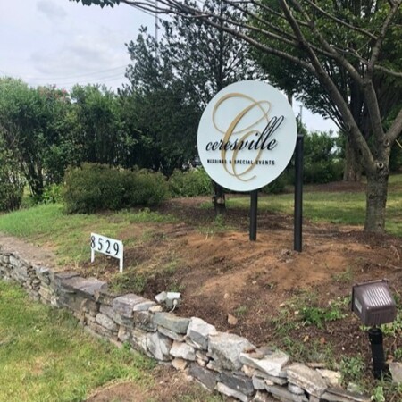 Ceresville Mansion post-mounted round sign in white with a gold C monogram, reading Weddings & Special Events.